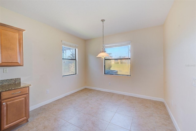 unfurnished dining area with light tile patterned flooring