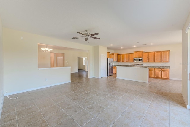 kitchen with appliances with stainless steel finishes, ceiling fan with notable chandelier, a center island, and light tile patterned floors