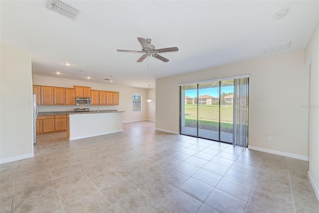 unfurnished living room with ceiling fan and light tile patterned flooring