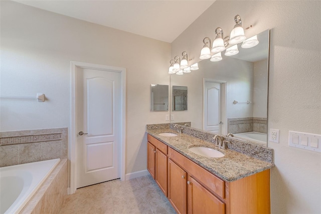 bathroom with tile patterned floors, tiled tub, and vanity