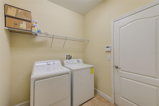 laundry area with washer and dryer, light tile patterned floors, and a textured ceiling