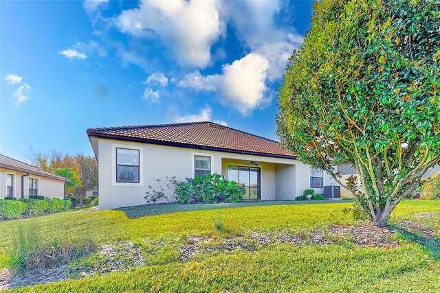 view of home's exterior with a lawn, ceiling fan, and central air condition unit