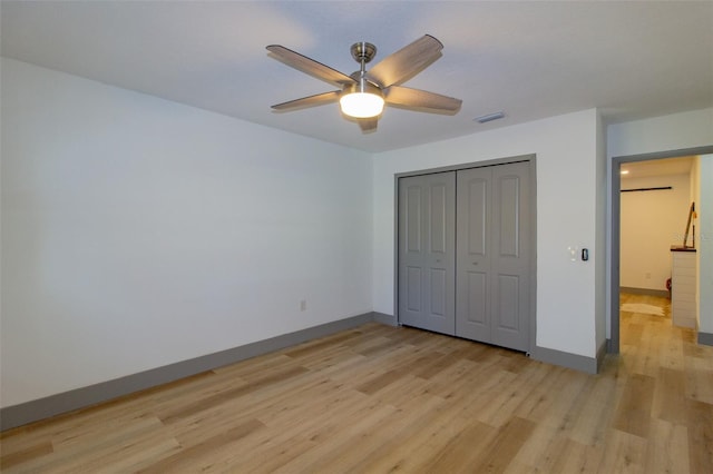 unfurnished bedroom with ceiling fan, light hardwood / wood-style floors, and a closet