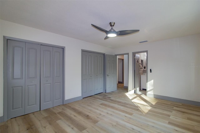 unfurnished bedroom with light hardwood / wood-style floors, ceiling fan, and multiple closets