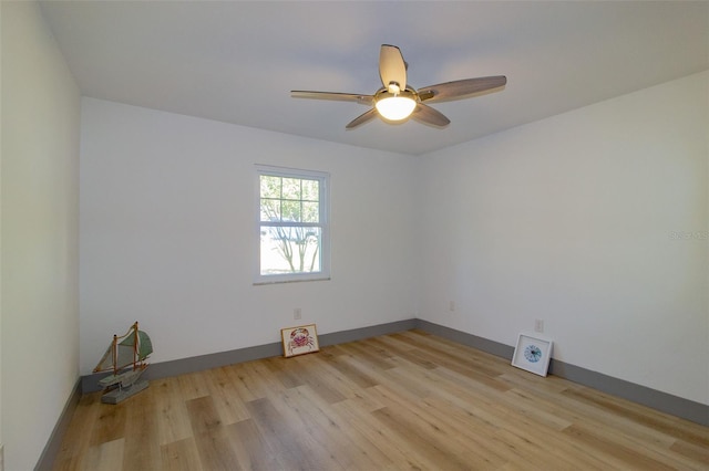 empty room with ceiling fan and light hardwood / wood-style floors