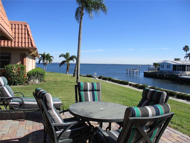 view of patio / terrace with a water view and a dock