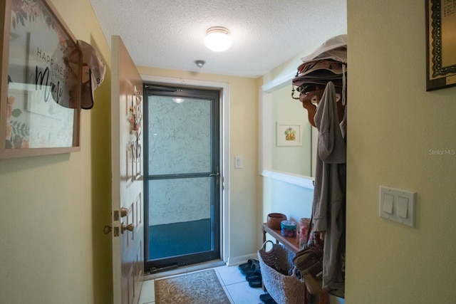 entryway with light tile patterned floors and a textured ceiling