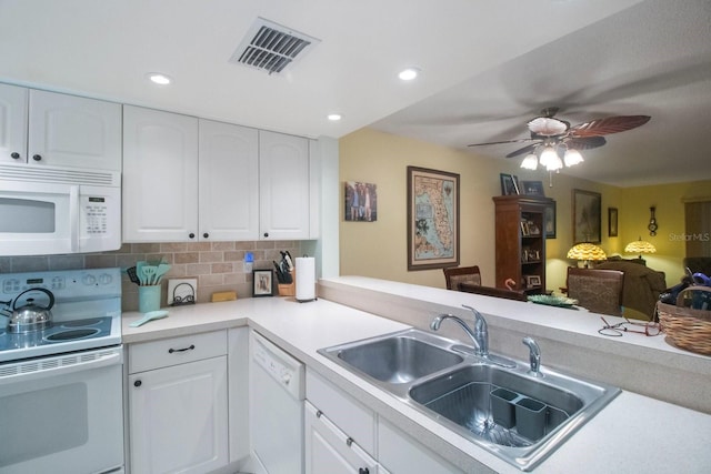 kitchen with white cabinetry, sink, kitchen peninsula, white appliances, and decorative backsplash