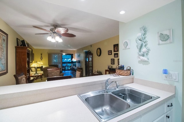 kitchen with white cabinets, ceiling fan, and sink