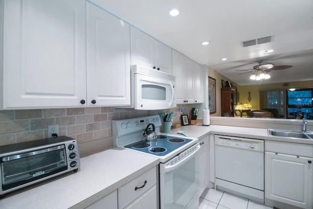 kitchen featuring white appliances, sink, decorative backsplash, and white cabinets