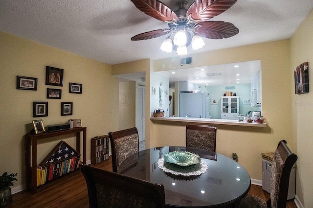 dining space with ceiling fan, hardwood / wood-style floors, and a textured ceiling