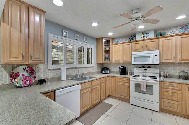 kitchen with light stone countertops, white appliances, tasteful backsplash, and sink