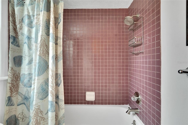 bathroom with shower / bathtub combination with curtain and a textured ceiling