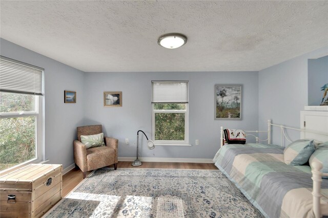 bedroom featuring light hardwood / wood-style floors and a textured ceiling