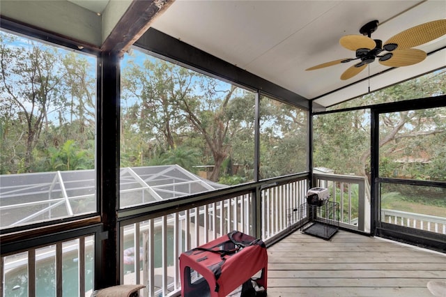 sunroom with ceiling fan and lofted ceiling