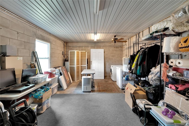 storage area featuring washer and dryer, ceiling fan, and water heater