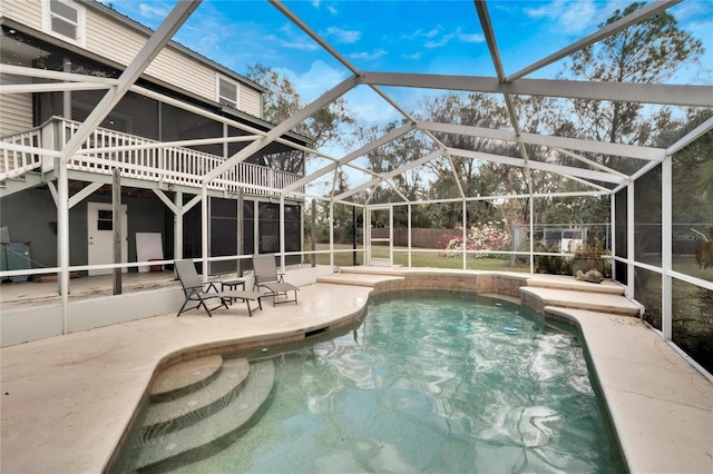 view of pool featuring glass enclosure and a patio area