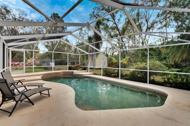 view of swimming pool with a lanai, a patio area, and a shed