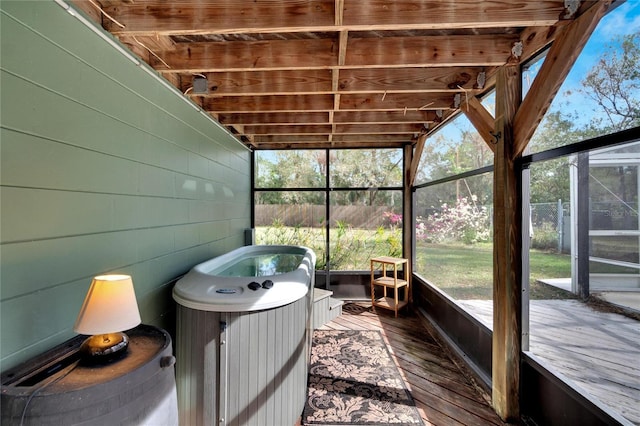 unfurnished sunroom with lofted ceiling with beams, a hot tub, plenty of natural light, and wood ceiling