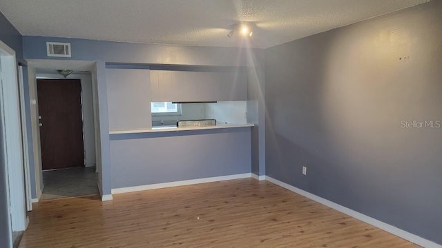 spare room with hardwood / wood-style floors and a textured ceiling