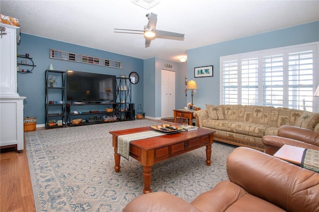 living room featuring light hardwood / wood-style flooring and ceiling fan