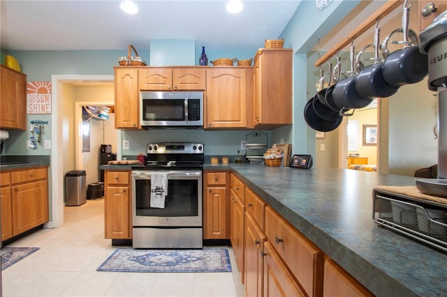 kitchen with light tile patterned floors and appliances with stainless steel finishes