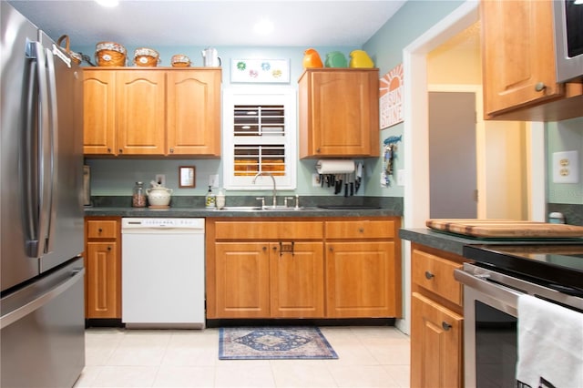 kitchen with stainless steel fridge, dishwasher, light tile patterned floors, and sink