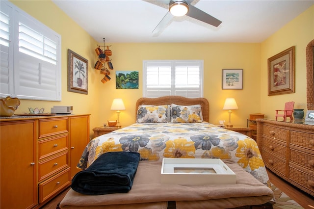 bedroom with multiple windows, wood-type flooring, and ceiling fan