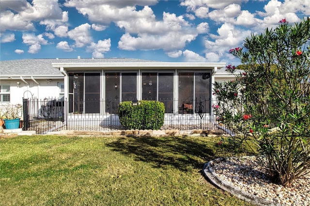 back of property featuring a yard and a sunroom