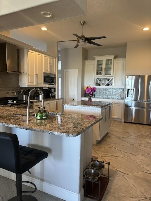 kitchen featuring a center island, stainless steel appliances, tasteful backsplash, a kitchen breakfast bar, and dark stone counters