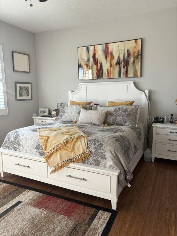 bedroom featuring a textured ceiling and dark wood-type flooring