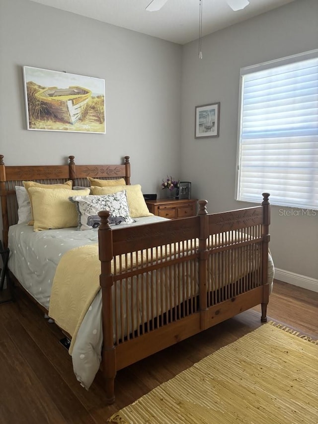 bedroom with dark hardwood / wood-style floors and ceiling fan