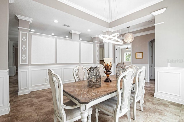 dining space featuring tile patterned floors, crown molding, and a notable chandelier