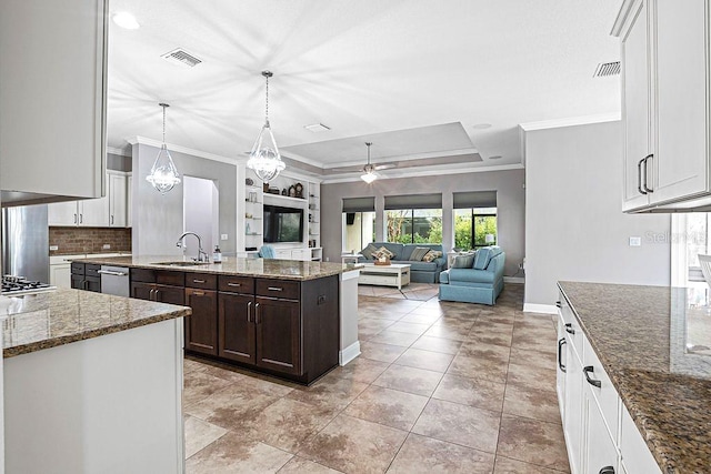 kitchen with dark brown cabinetry, light stone countertops, white cabinetry, a center island, and hanging light fixtures