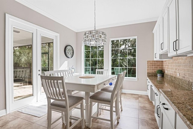 dining area featuring light tile patterned floors, ornamental molding, and a notable chandelier