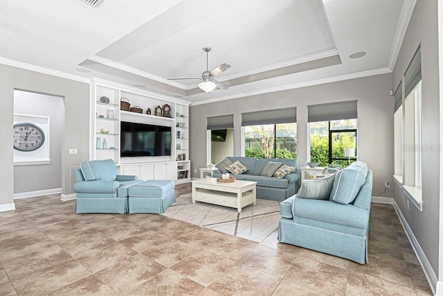 living room with built in shelves, ceiling fan, a raised ceiling, and ornamental molding