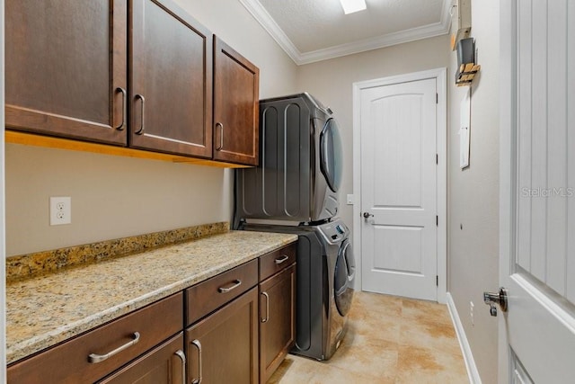 clothes washing area with cabinets, stacked washer / drying machine, and ornamental molding