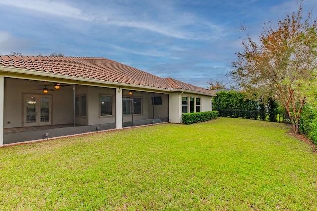 rear view of house featuring a lawn and ceiling fan