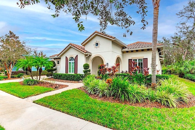 mediterranean / spanish-style house featuring a front yard