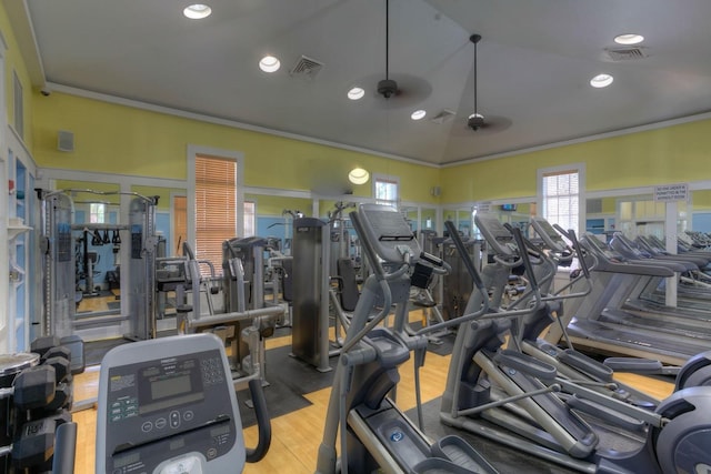 gym with ceiling fan, light hardwood / wood-style floors, ornamental molding, and vaulted ceiling