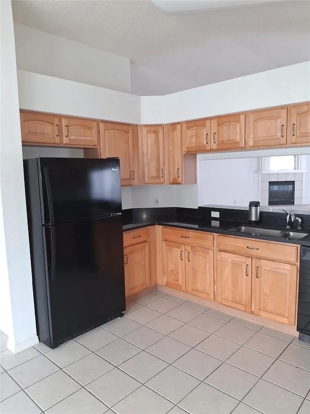 kitchen featuring light tile patterned flooring, sink, and black appliances