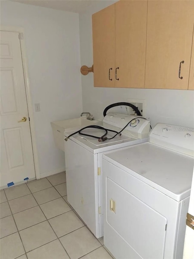 laundry room with light tile patterned flooring, cabinets, and independent washer and dryer