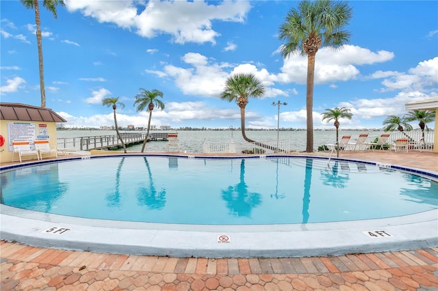 view of pool featuring a patio and a water view