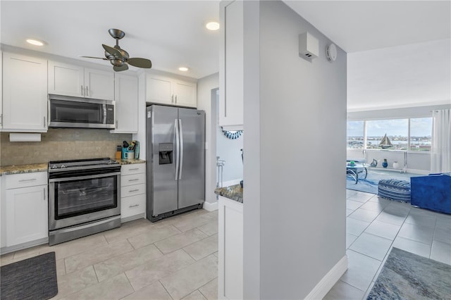 kitchen featuring ceiling fan, light stone counters, white cabinets, and appliances with stainless steel finishes