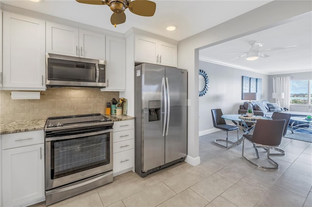 kitchen featuring white cabinetry, stainless steel appliances, light stone counters, crown molding, and decorative backsplash