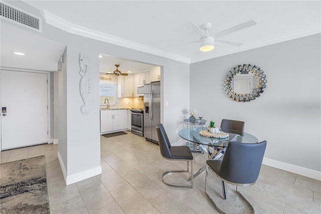 dining area with crown molding, sink, ceiling fan, and light tile patterned floors