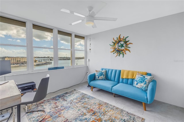 tiled office featuring ceiling fan and a water view