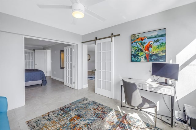 office space featuring a barn door, ceiling fan, french doors, and ornamental molding