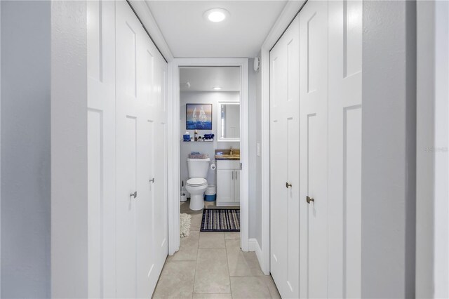 hallway featuring light tile patterned floors and sink