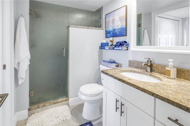 bathroom with tile patterned flooring, vanity, toilet, and walk in shower